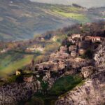 Vista panoramica del suggestivo piccolo paese nel Lazio, con case in pietra e paesaggio verde circostante.