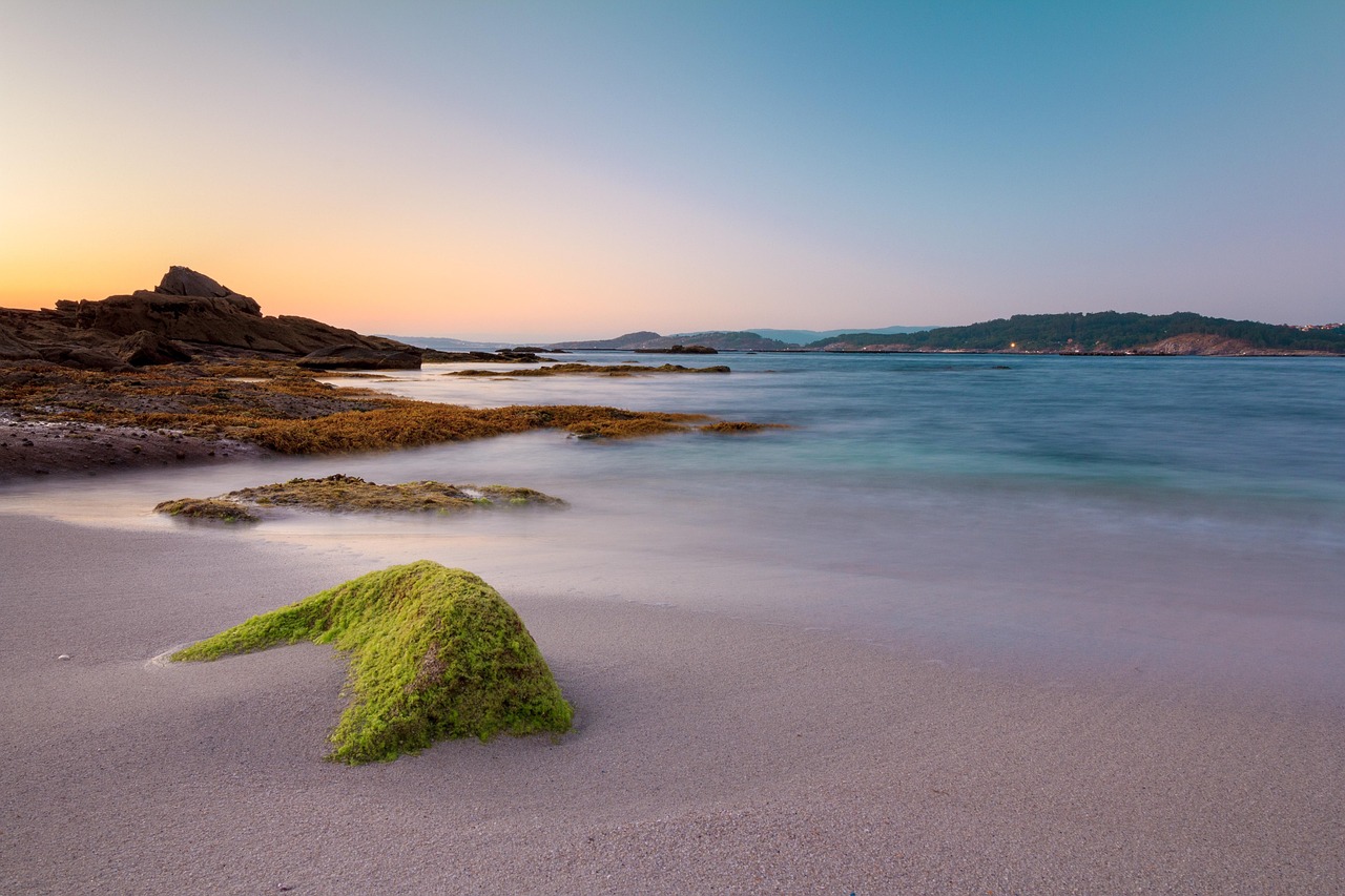 Spiaggia sarda all'alba, onde brillanti sotto il sole nascente, atmosfera magica e suggestiva.