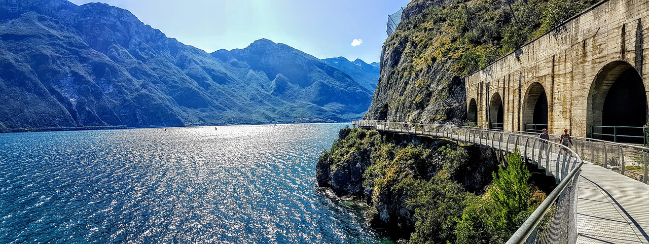Lago italiano con acque turchesi circondato da montagne, simile a un fiordo norvegese.