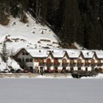 Lago di Braies immerso nella natura, riflessi delle montagne sulle acque cristalline.
