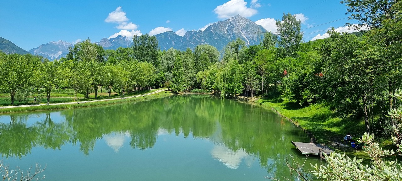 Lago del Trentino con acque cristalline e montagne sullo sfondo, vista mozzafiato che sembra un dipinto.