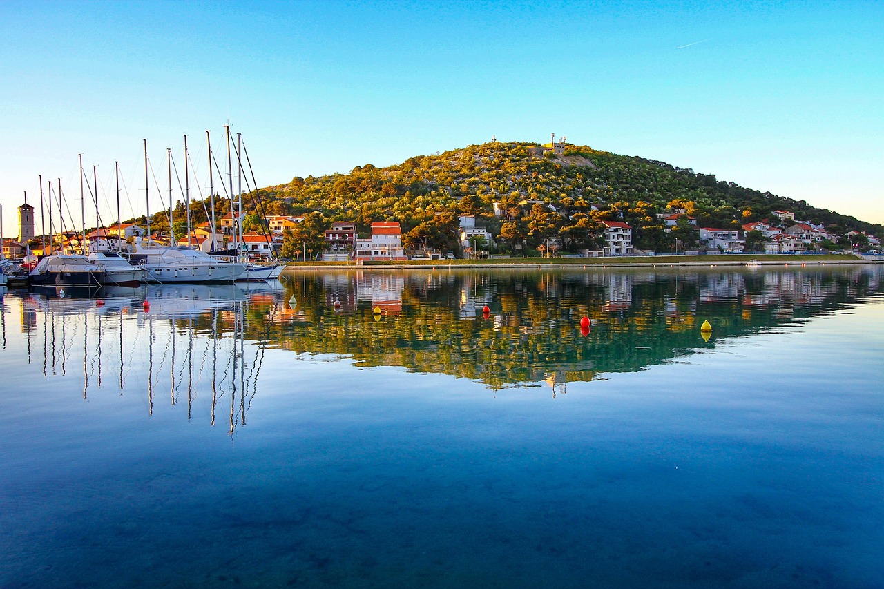 Panorama di una pittoresca cittadina costiera croata con mare cristallino e case colorate.