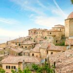 Panorama del villaggio marchigiano con vista sul mare, caratterizzato da colori vivaci e paesaggi incantevoli.