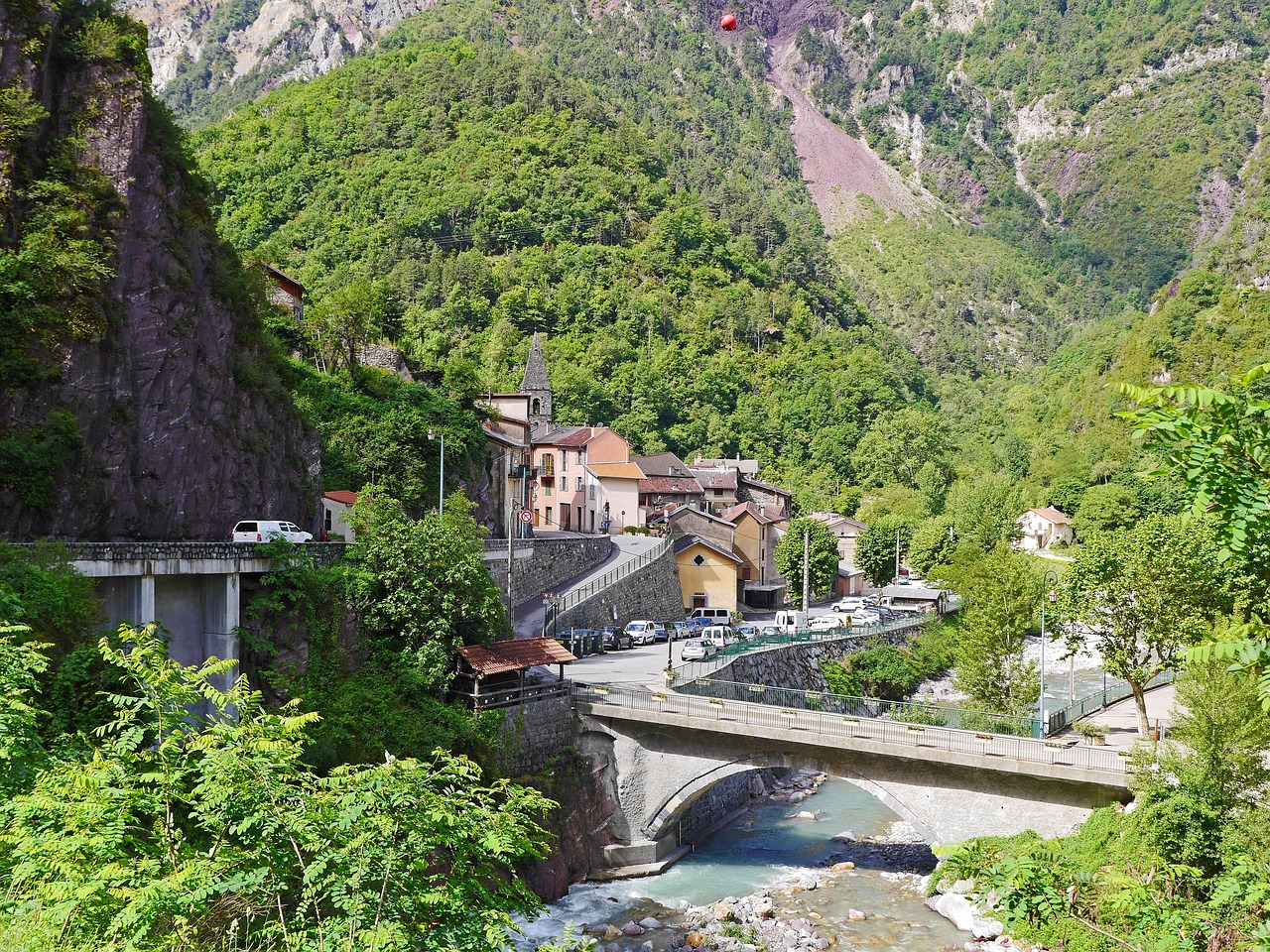 Panorama di un pittoresco paese italiano con stradine acciottolate e case colorate, simile a una cartolina.