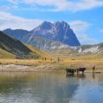 Vista panoramica del lago di Scaffaiolo circondato da montagne durante un'escursione nell'Appennino.