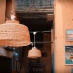 Vista panoramica del borgo di Castelsardo con la rocca e i cestini intrecciati in primo piano.