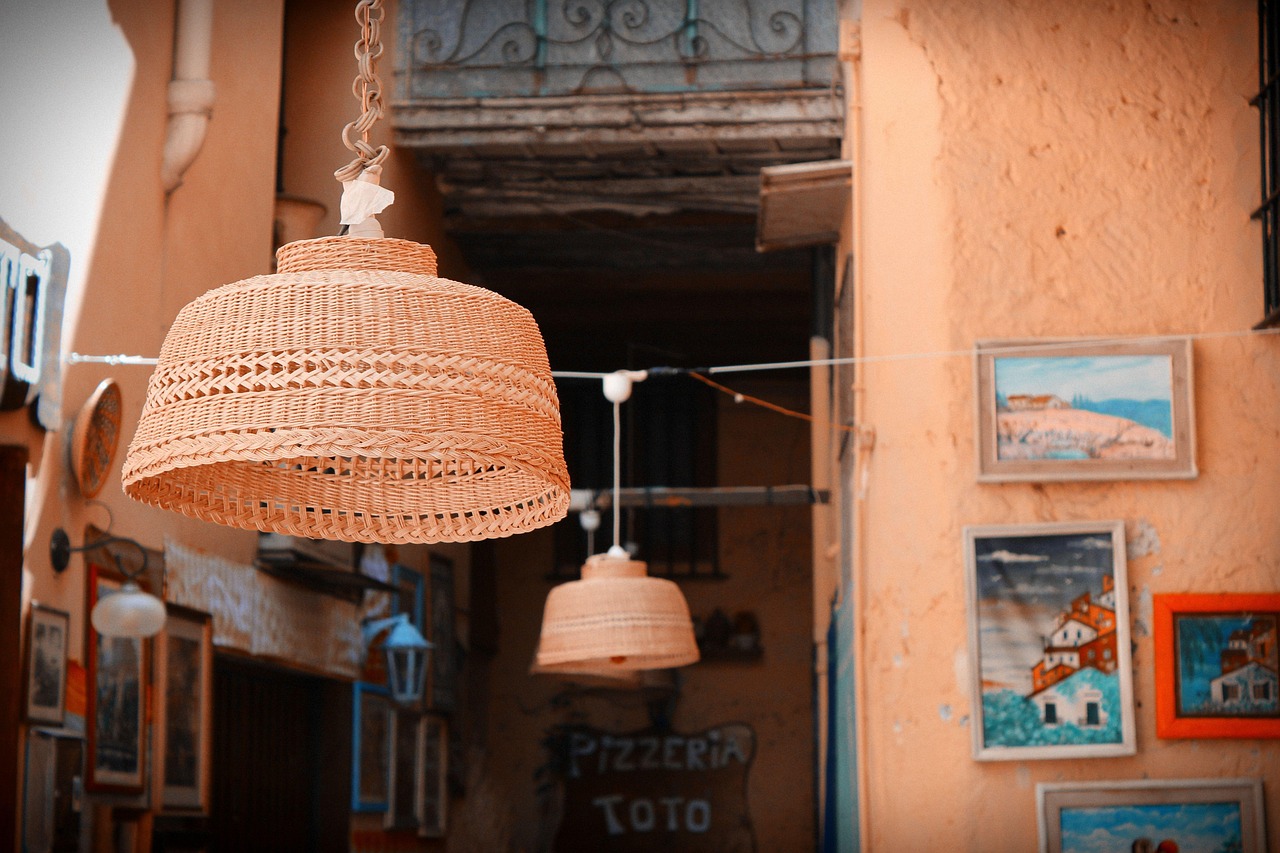 Vista panoramica del borgo di Castelsardo con la rocca e i cestini intrecciati in primo piano.