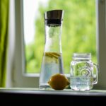 Bottiglia d'acqua accanto a un letto, simbolo di idratazione per un sonno migliore.