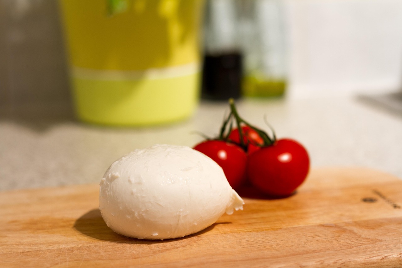 Mozzarella di bufala su un tagliere, evidenziando la sua consistenza compatta e non filante.