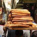 Panorama di un pittoresco paese con forni tradizionali e profumo di pane fresco nell'aria.