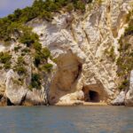 Spiaggia di Torre dell'Orso con sabbia bianca e grotte da esplorare, ideale per una giornata di relax.