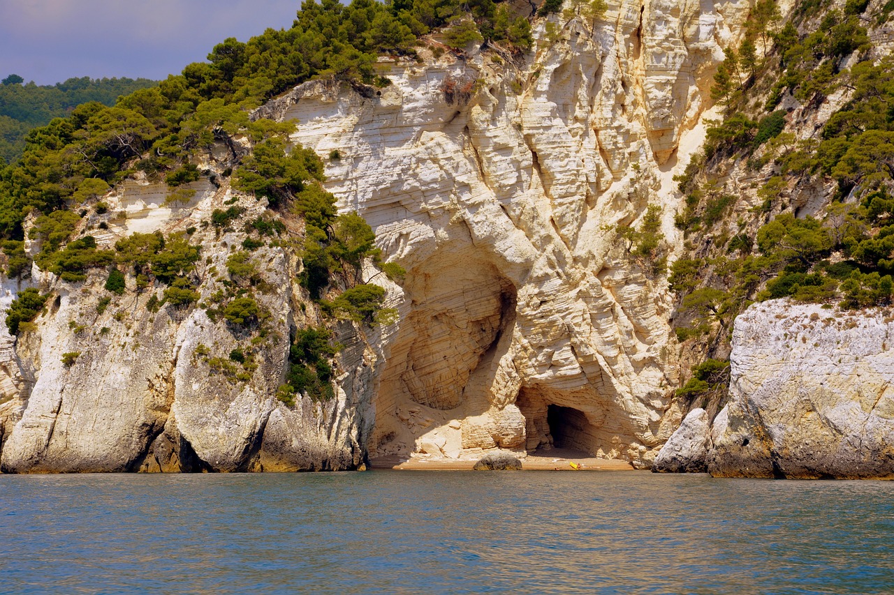 Spiaggia di Torre dell'Orso con sabbia bianca e grotte da esplorare, ideale per una giornata di relax.