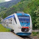 Panorama della ferrovia transiberiana d'Italia, circondata da montagne innevate e paesaggi suggestivi.
