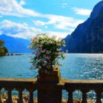Panorama del lago italiano nascosto, circondato da montagne e vegetazione, con riflessi sull'acqua.