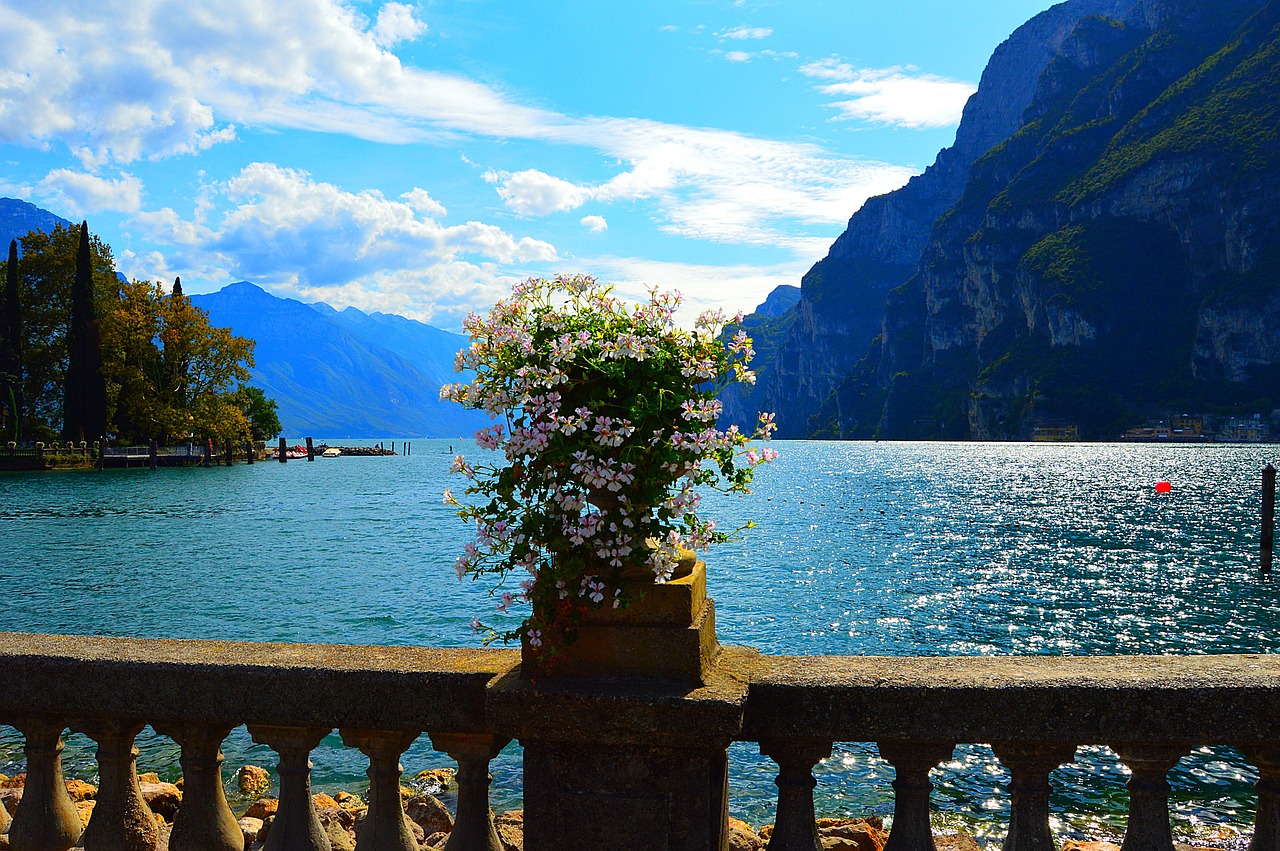 Panorama del lago italiano nascosto, circondato da montagne e vegetazione, con riflessi sull'acqua.