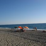 Spiaggia calabrese con acque cristalline e sole splendente, un vero paradiso nascosto.