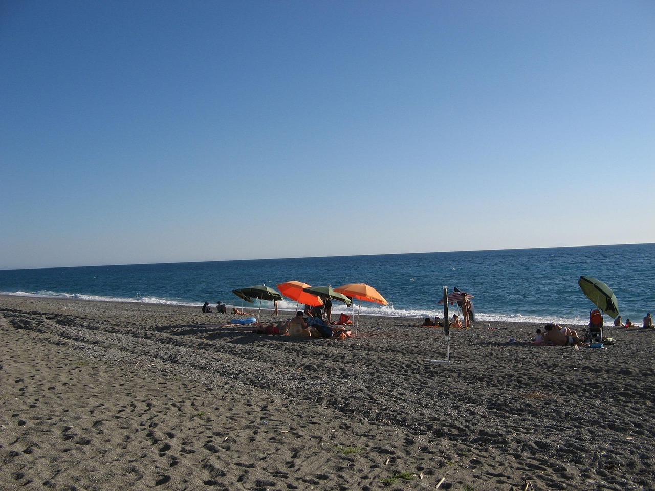 Spiaggia calabrese con acque cristalline e sole splendente, un vero paradiso nascosto.