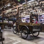 Fattoria di mozzarella di bufala in Campania, con bufali al pascolo e piatti tipici sulla tavola.