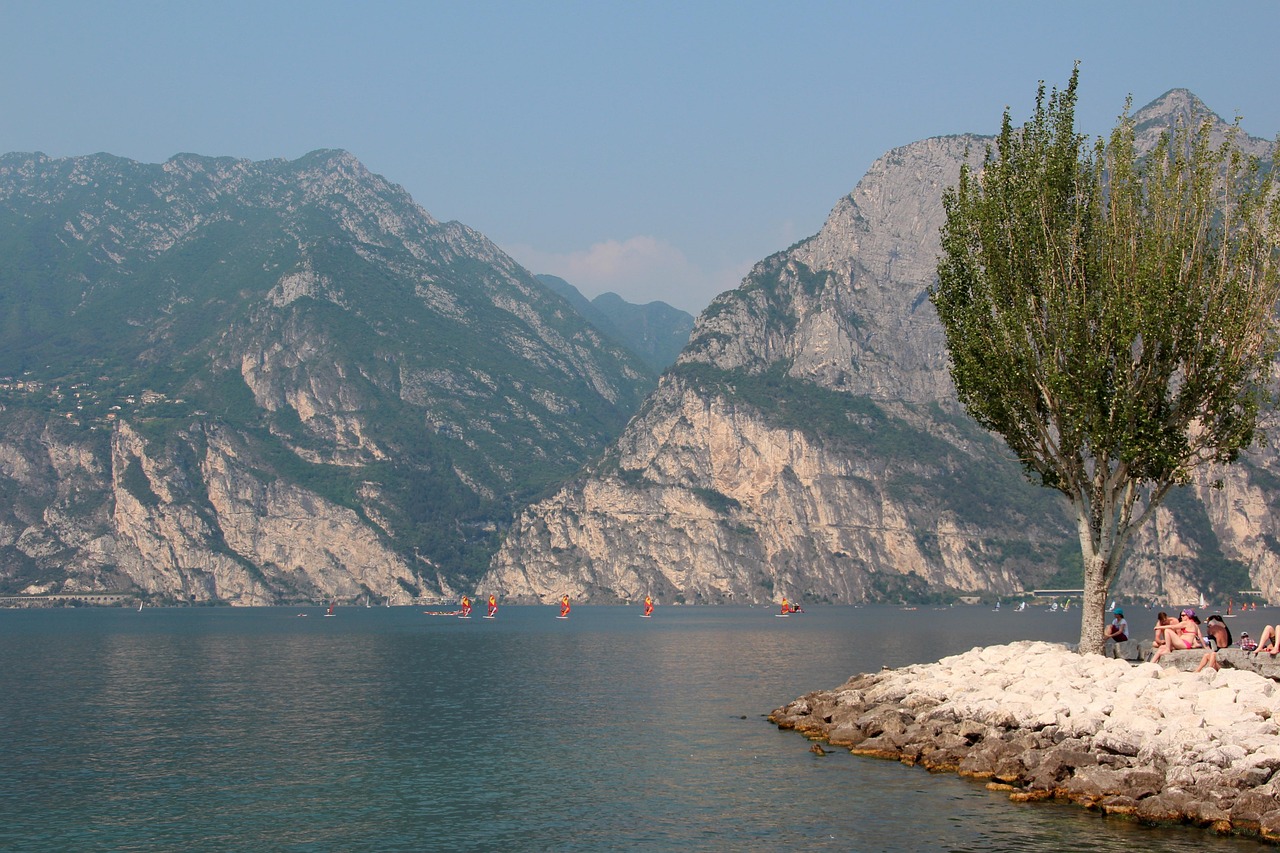 Lago italiano con acque blu profondo, circondato da montagne simili ai fiordi norvegesi.