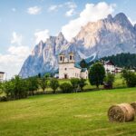 Panorama mozzafiato delle Dolomiti in Trentino Alto Adige, con valli verdi e montagne maestose.