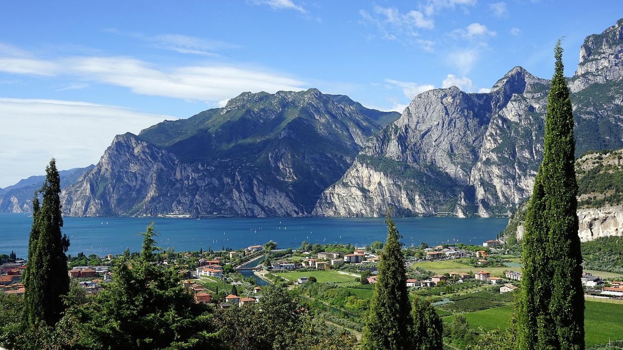 Vista panoramica del lago italiano che ricorda un fiordo norvegese, circondato da montagne verdi.
