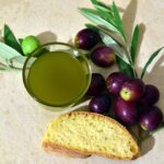 Olive e olio extravergine di oliva in un paesaggio umbro tipico, simbolo della tradizione culinaria locale.