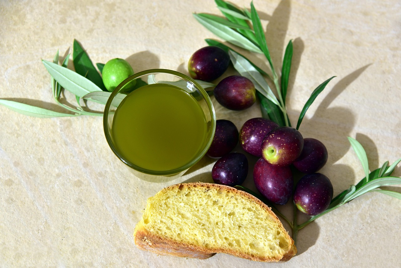 Olive e olio extravergine di oliva in un paesaggio umbro tipico, simbolo della tradizione culinaria locale.
