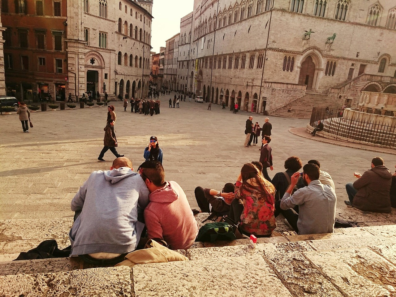 Panorama di Perugia con turisti che esplorano le sue strade storiche e monumenti.