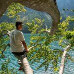 Lago di Molveno con acque turchesi, simili a quelle caraibiche, circondato da montagne.