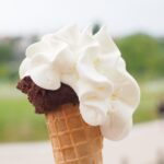 Gelato artigianale servito in un borgo toscano, con vista sulle colline circostanti.