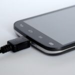 Caricabatterie del telefono collegato a una presa elettrica con un telefono sopra.