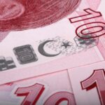 Banconota in primo piano con data di dismissione del 27 gennaio e simboli di valuta.