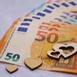 Anziana sorride mentre legge un documento informativo sulle spese da eliminare dopo i 70 anni.