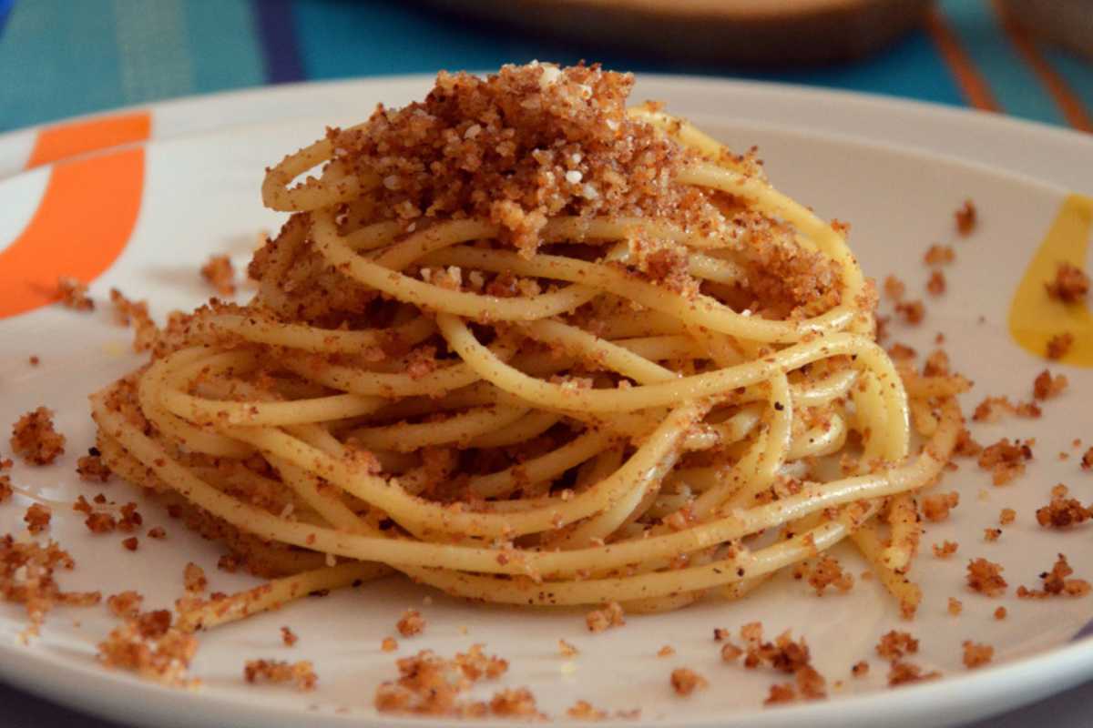 Pasta con bottarga servita in un piatto, decorata con prezzemolo fresco.
