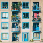 Anziani discutono delle spese condominiali in un ambiente domestico, con documenti e calcolatrice.